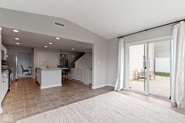 5776 Blue Sky Dr, Whitestown, IN 46075 - kitchen featuring lofted ceiling, white cabinets, stainless steel appliances, light stone counters, and recessed lighting