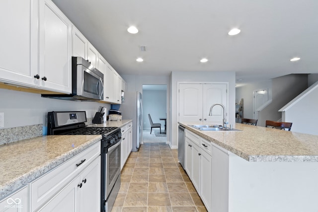 5776 Blue Sky Dr, Whitestown, IN 46075 - kitchen with appliances with stainless steel finishes, light countertops, white cabinetry, a center island with sink, and recessed lighting