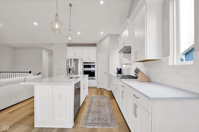 15744 Kohut Ln, Westfield, IN 46074 - kitchen featuring under cabinet range hood, stainless steel appliances, backsplash, white cabinetry, and recessed lighting