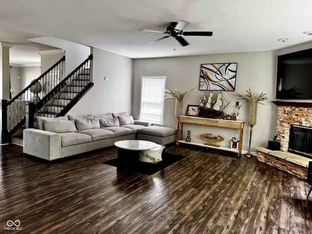 12583 Courage Xing, Fishers, IN 46037 - living room with wood finished floors, stairs, a ceiling fan, a fireplace, and a textured ceiling