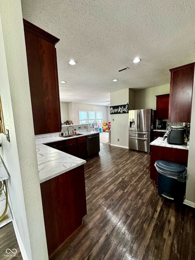 12583 Courage Xing, Fishers, IN 46037 - kitchen with a peninsula, stainless steel fridge, a textured ceiling, dark wood-style flooring, and recessed lighting