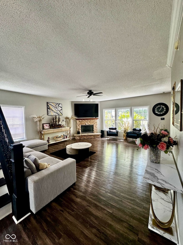 12583 Courage Xing, Fishers, IN 46037 - living room with ceiling fan, a textured ceiling, wood finished floors, a fireplace, and stairway