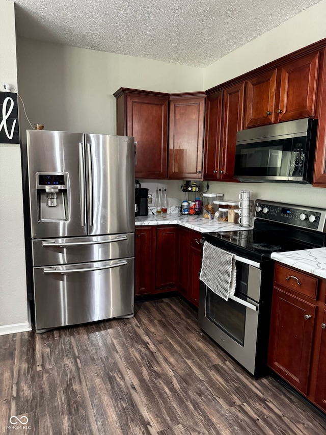 12583 Courage Xing, Fishers, IN 46037 - kitchen featuring appliances with stainless steel finishes, dark wood-type flooring, a textured ceiling, and light stone counters