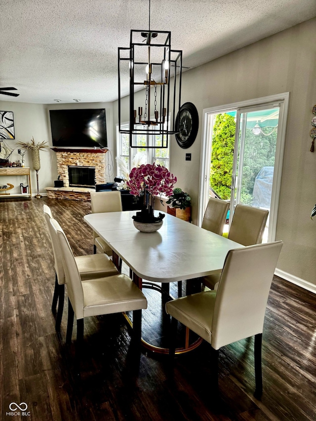 12583 Courage Xing, Fishers, IN 46037 - dining room featuring wood finished floors, a textured ceiling, and a stone fireplace