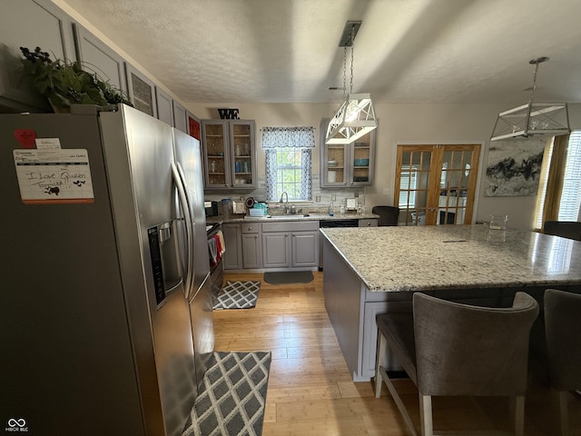 611 Crossfield Ct, Indianapolis, IN 46239 - kitchen featuring stainless steel appliances, light wood-type flooring, french doors, a breakfast bar area, and gray cabinets