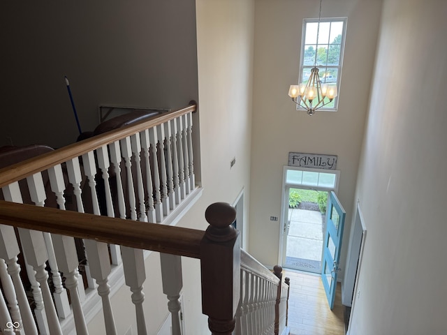 611 Crossfield Ct, Indianapolis, IN 46239 - stairs featuring a chandelier, a towering ceiling, and wood finished floors