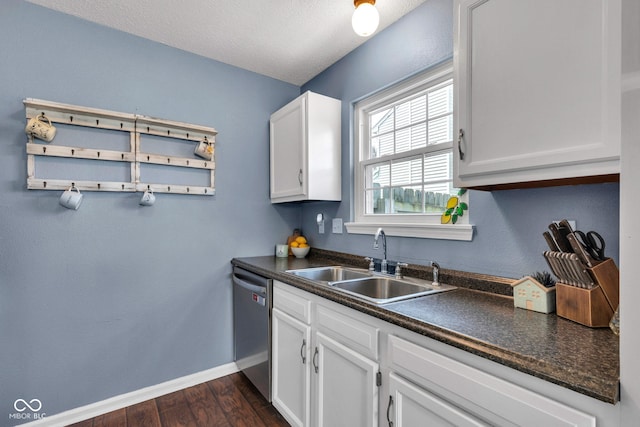 7702 Wood Stream Dr, Indianapolis, IN 46239 - kitchen featuring stainless steel dishwasher, dark countertops, dark wood-style floors, white cabinetry, and a textured ceiling