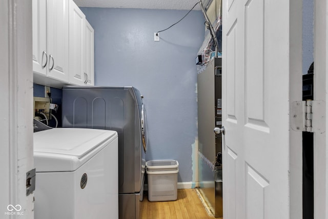 7702 Wood Stream Dr, Indianapolis, IN 46239 - washroom with cabinet space, washing machine and dryer, and light wood-style flooring