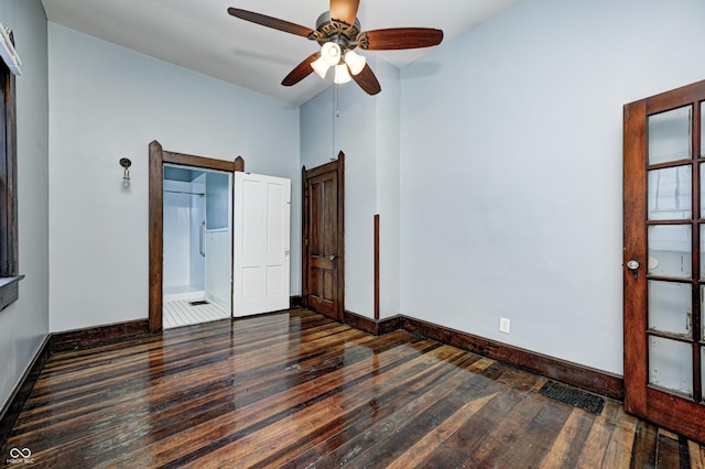 832 Noble St, Indianapolis, IN 46203 - unfurnished bedroom featuring wood-type flooring, a ceiling fan, and a barn door