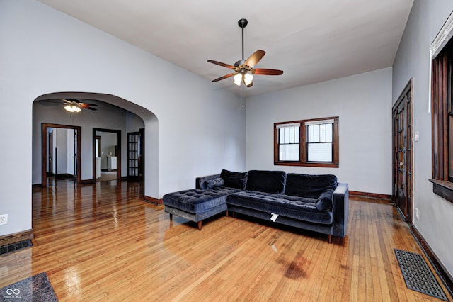 832 Noble St, Indianapolis, IN 46203 - living room with arched walkways, ceiling fan, and light wood-style floors