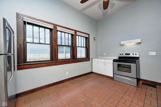 832 Noble St, Indianapolis, IN 46203 - kitchen featuring appliances with stainless steel finishes, a ceiling fan, brick floors, light countertops, and white cabinets