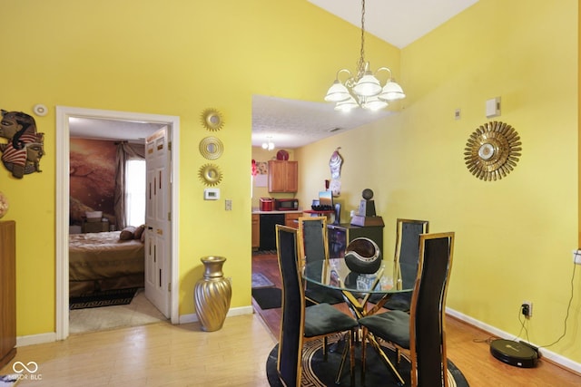 6117 Salanie Pl, Indianapolis, IN 46254 - dining space with light wood-type flooring, high vaulted ceiling, and a chandelier