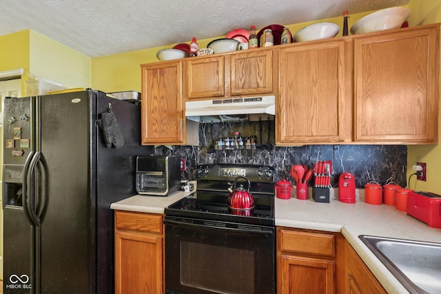 6117 Salanie Pl, Indianapolis, IN 46254 - kitchen with black appliances, under cabinet range hood, light countertops, decorative backsplash, and a textured ceiling