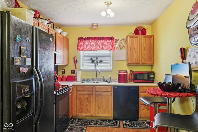 6117 Salanie Pl, Indianapolis, IN 46254 - kitchen with black appliances, light countertops, wood finished floors, a textured ceiling, and under cabinet range hood