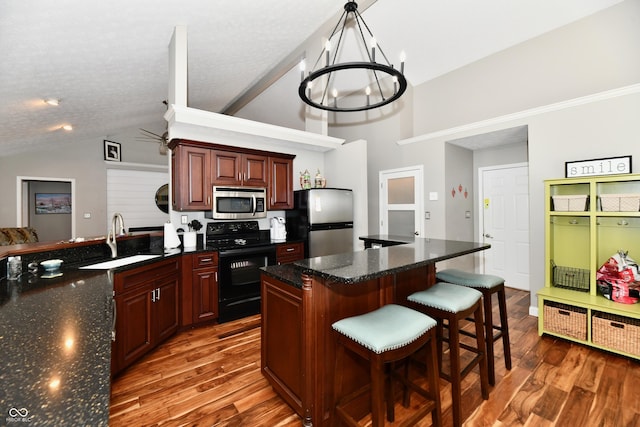 114 Sunrise Ln, Lizton, IN 46149 - kitchen with appliances with stainless steel finishes, dark wood-style flooring, a chandelier, a kitchen breakfast bar, and high vaulted ceiling