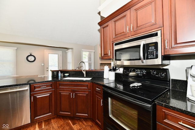 114 Sunrise Ln, Lizton, IN 46149 - kitchen with appliances with stainless steel finishes, dark wood-style flooring, dark stone counters, and a peninsula