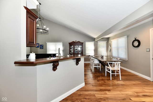 114 Sunrise Ln, Lizton, IN 46149 - kitchen with lofted ceiling, a kitchen breakfast bar, light wood finished floors, pendant lighting, and a peninsula