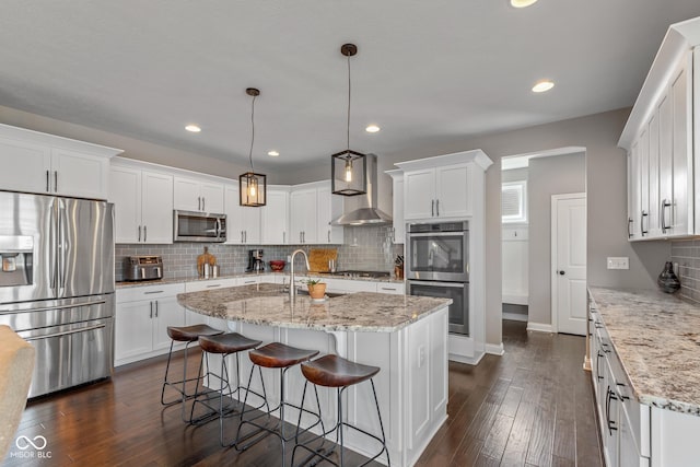 16338 Portage Trail Ln, Fortville, IN 46040 - kitchen featuring stainless steel appliances, wall chimney exhaust hood, white cabinets, backsplash, and dark wood-style floors