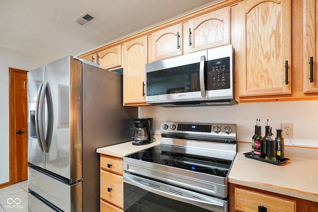 4001 Oakfield Dr, Indianapolis, IN 46237 - kitchen with stainless steel appliances, light brown cabinets, light countertops, and light tile patterned floors