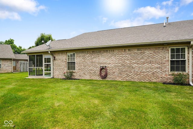 4001 Oakfield Dr, Indianapolis, IN 46237 - back of property featuring a sunroom, a yard, brick siding, and a shingled roof