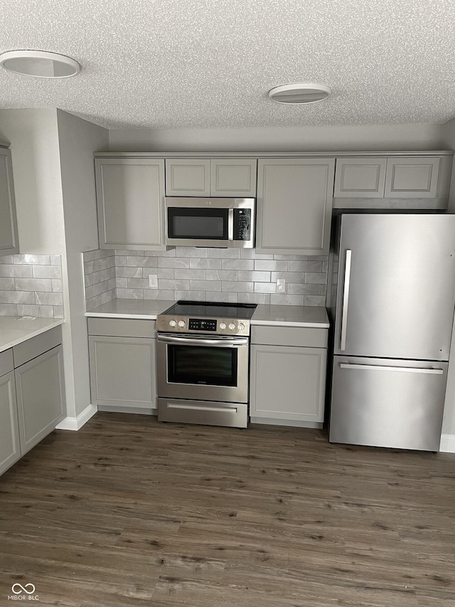 9701 W Constellation Dr, Pendleton, IN 46064 - kitchen with stainless steel appliances, gray cabinets, a textured ceiling, tasteful backsplash, and light countertops