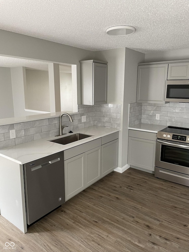 9701 W Constellation Dr, Pendleton, IN 46064 - kitchen featuring appliances with stainless steel finishes, gray cabinets, a textured ceiling, and backsplash