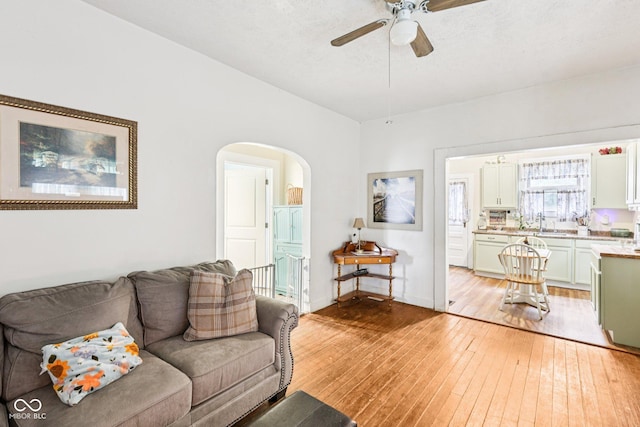 2933 S E St, Indianapolis, IN 46225 - living room with light wood finished floors, arched walkways, and ceiling fan