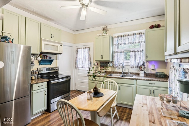 2933 S E St, Indianapolis, IN 46225 - kitchen featuring appliances with stainless steel finishes, green cabinets, ceiling fan, dark wood-style floors, and dark countertops