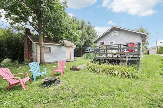 2933 S E St, Indianapolis, IN 46225 - rear view of house featuring an outdoor fire pit, a yard, a deck, and an outdoor structure