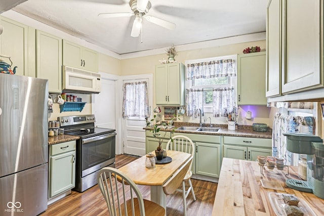 2933 S E St, Indianapolis, IN 46225 - kitchen featuring appliances with stainless steel finishes, green cabinetry, wood finished floors, and a ceiling fan
