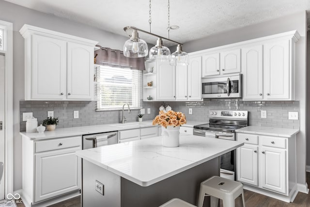 2025 W Morse Dr, Cicero, IN 46034 - kitchen featuring appliances with stainless steel finishes, white cabinetry, a kitchen breakfast bar, a textured ceiling, and a kitchen island
