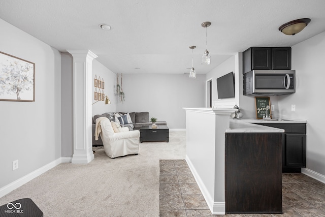 2025 W Morse Dr, Cicero, IN 46034 - kitchen with stainless steel microwave, ornate columns, decorative light fixtures, light countertops, and open floor plan