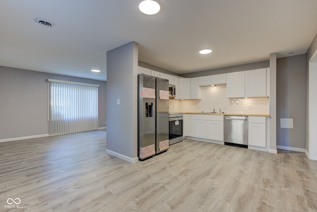 1453 Churchill Rd, Franklin, IN 46131 - kitchen with appliances with stainless steel finishes, light wood-type flooring, white cabinets, and recessed lighting
