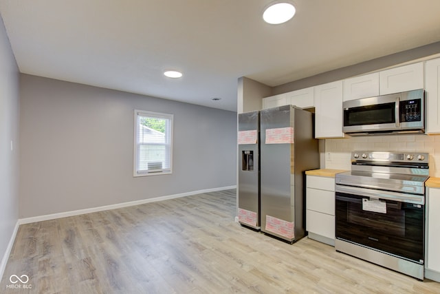 1453 Churchill Rd, Franklin, IN 46131 - kitchen featuring appliances with stainless steel finishes, white cabinetry, light wood-style flooring, backsplash, and recessed lighting