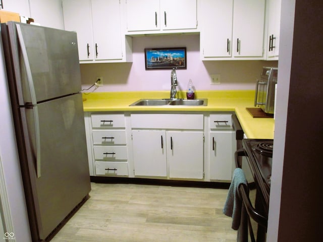 6808 Summer Time Dr, Indianapolis, IN 46226 - kitchen featuring freestanding refrigerator, electric range, light countertops, and white cabinets