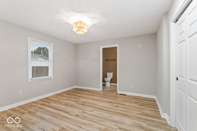 3369 N Chester Ave, Indianapolis, IN 46218 - unfurnished bedroom with a closet, light wood-style flooring, and connected bathroom
