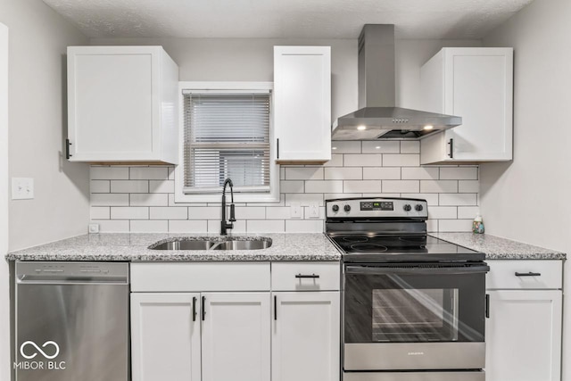 3369 N Chester Ave, Indianapolis, IN 46218 - kitchen with stainless steel appliances, wall chimney range hood, white cabinetry, and backsplash