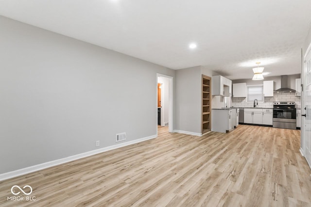 3369 N Chester Ave, Indianapolis, IN 46218 - unfurnished living room featuring light wood-type flooring and recessed lighting