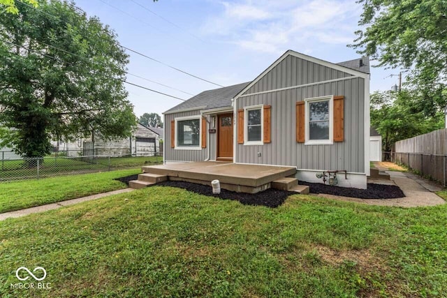 3369 N Chester Ave, Indianapolis, IN 46218 - view of front of property featuring board and batten siding, a deck, a fenced backyard, and roof with shingles