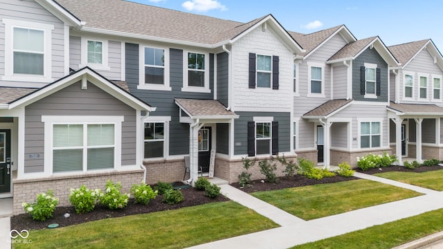 7239 Governors Row, Avon, IN 46123 - townhome / multi-family property with a front yard, brick siding, and a shingled roof