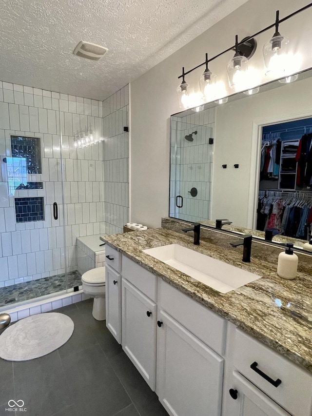 8202 Stonelick Dr, Avon, IN 46123 - bathroom with vanity, a stall shower, tile patterned floors, a walk in closet, and a textured ceiling