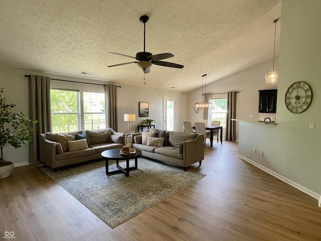 8202 Stonelick Dr, Avon, IN 46123 - living area featuring a textured ceiling, ceiling fan, wood finished floors, vaulted ceiling, and a chandelier