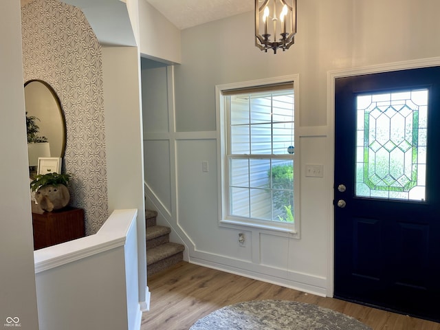 8202 Stonelick Dr, Avon, IN 46123 - entryway featuring wood finished floors, stairway, a chandelier, and a decorative wall
