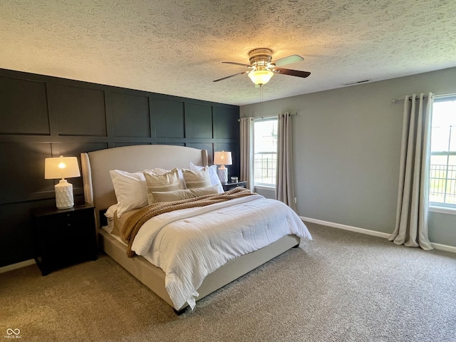 8202 Stonelick Dr, Avon, IN 46123 - bedroom featuring light colored carpet, multiple windows, a textured ceiling, ceiling fan, and a decorative wall