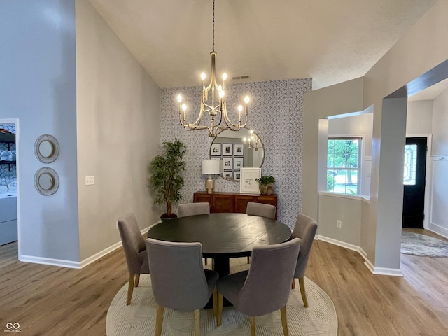 8202 Stonelick Dr, Avon, IN 46123 - dining space with a chandelier, wood finished floors, an accent wall, and wallpapered walls