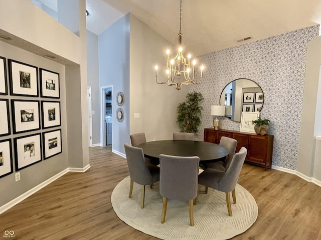 8202 Stonelick Dr, Avon, IN 46123 - dining room featuring a chandelier, wallpapered walls, wood finished floors, and high vaulted ceiling