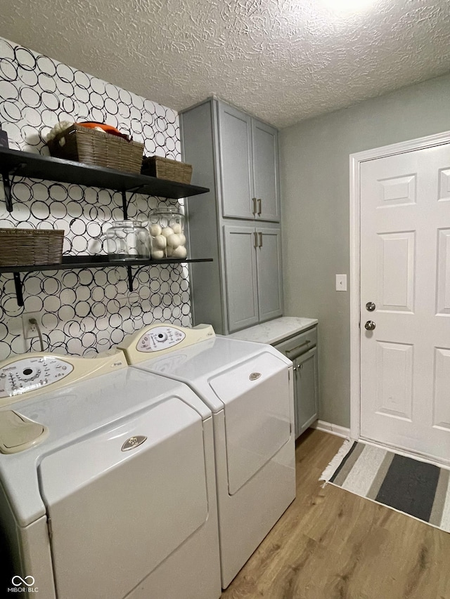 8202 Stonelick Dr, Avon, IN 46123 - laundry room with cabinet space, separate washer and dryer, light wood-style flooring, and a textured ceiling