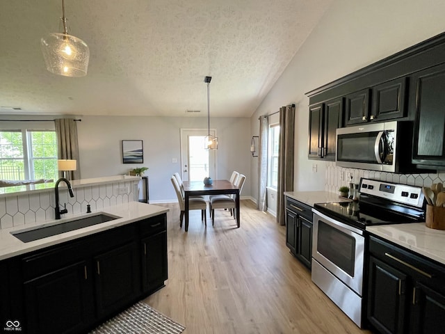 8202 Stonelick Dr, Avon, IN 46123 - kitchen with stainless steel appliances, dark cabinetry, decorative backsplash, a textured ceiling, and vaulted ceiling