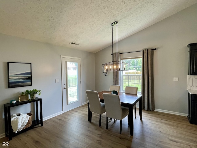 8202 Stonelick Dr, Avon, IN 46123 - dining space with a textured ceiling, wood finished floors, a chandelier, and lofted ceiling