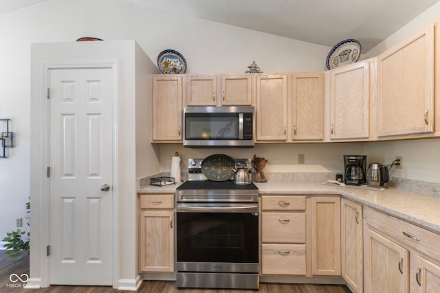 7009 Thousand Oaks Ln, Indianapolis, IN 46214 - kitchen featuring stainless steel appliances, light brown cabinets, lofted ceiling, wood finished floors, and light countertops